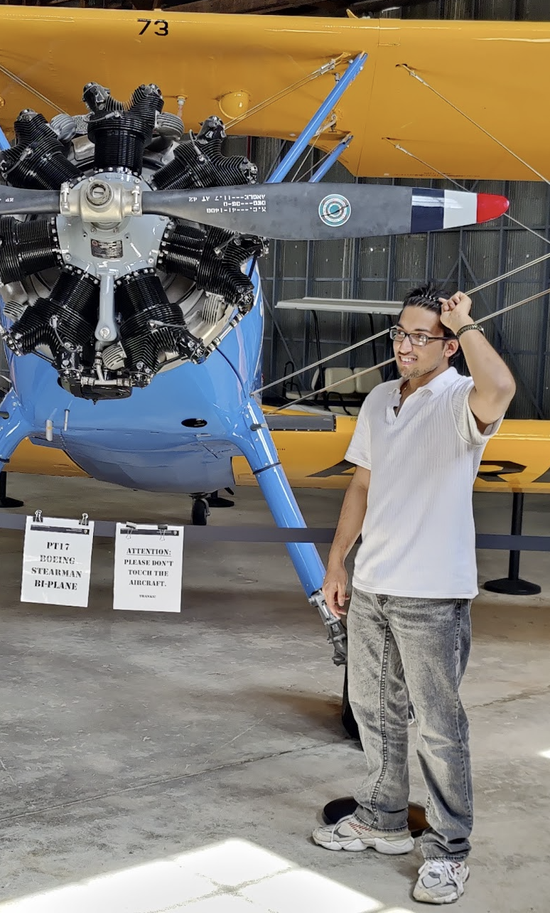 Vedarsh beside a vintage airplane